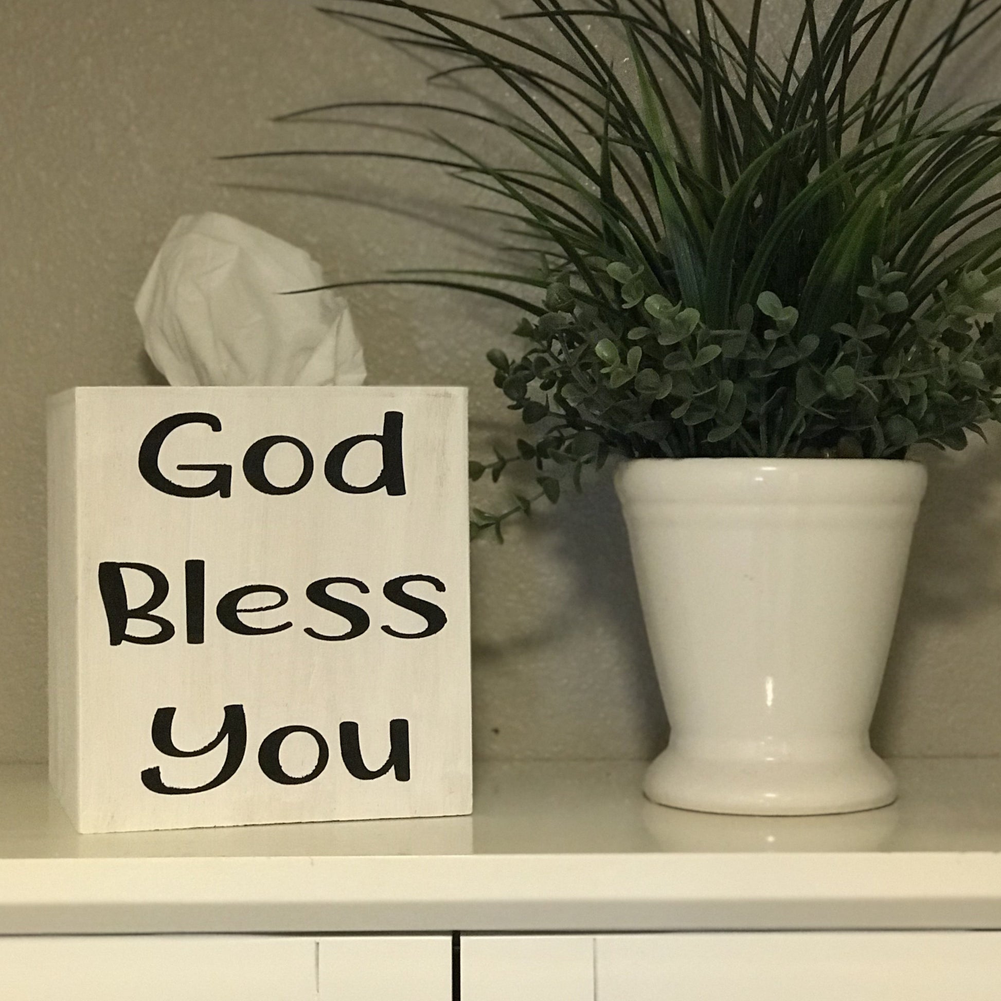 The wooden box measures 5.75 inch x 5.25 inch and will fit any standard size facial tissue box. The box is painted in white. The saying "God Bless You" is painted on in black. Saying is on one side only.