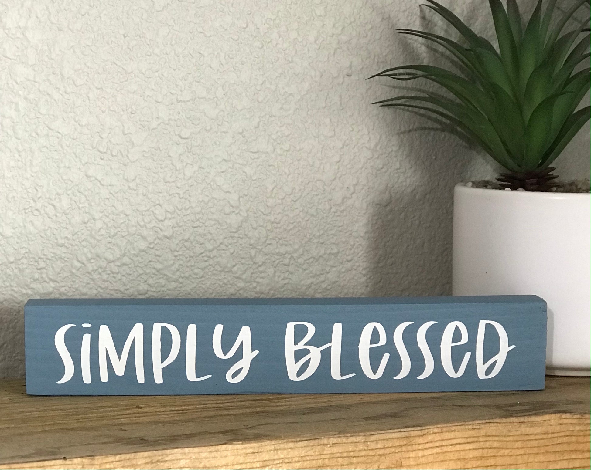 This cute, yet simple wood stick sign is 8 inch x 1 inch and is a perfect accent to your home decor. This sign is painted in a blueish gray color with the saying simply blessed in white. 